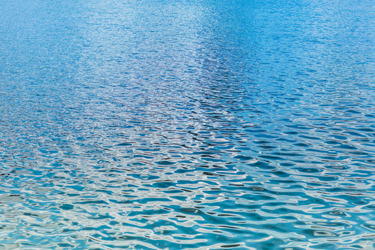 Close up abstract photo of lake, reiver, sea or ocean water surface. Beautiful smooth gradient blue and green color ripple from reflection of sun light.