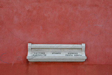 An old mailbox of white marble that says: 