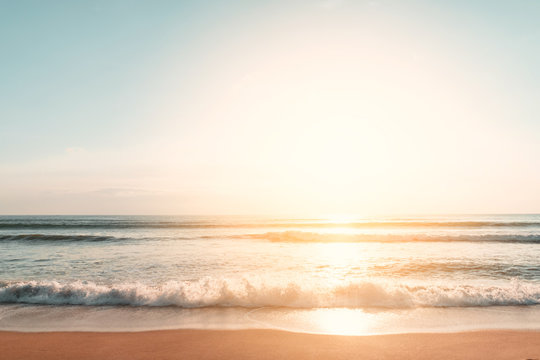 Tropical beach with smooth wave and sunset sky abstract background.