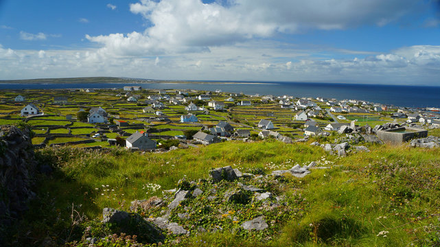 Auf Irland mit einer Aufsicht auf eine kleine Siedlung und Meer