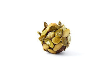 Healthy energy ball made of dates and covered with pumpkin seeds isolated on the white background. Organic candy made with dates, raisins, peanuts and pumpkin seeds.