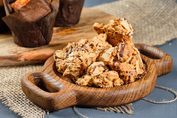 caramel waffles on a wooden plate and cupcakes on a gray background. Rustic style