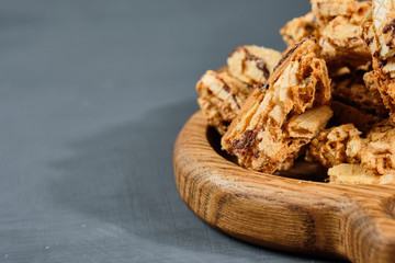 caramel waffles on a wooden plate on a gray background. Rustic style