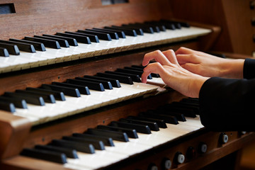 A woman playing the pipe organ  - obrazy, fototapety, plakaty