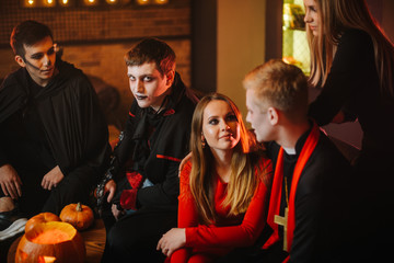 Guy in Count Dracula's Halloween costume is sitting with friends in a cafe and looking at the camera