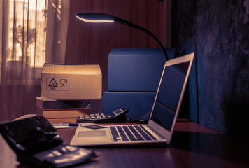 Laptop, calculator, boxes on the table. Late evening, online shopping. Concept