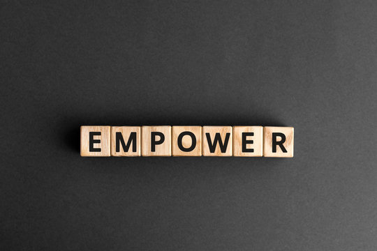empower - word from wooden blocks with letters, empower concept, gray background