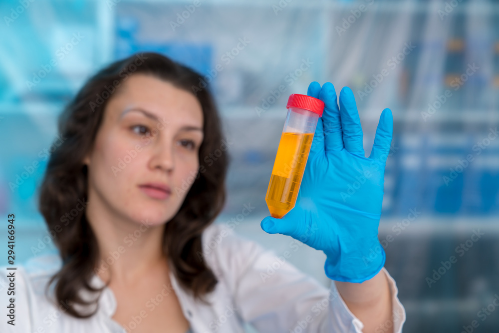 Poster Young woman in chemical lab Young woman in chemical lab. cience professional pipetting solution into the glass cuvette.