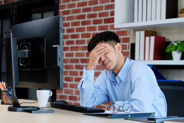 Fototapeta premium Young asian office man struggle with computer, Frustrated asian business man looking at computer while working at office, Business people struggle with technology