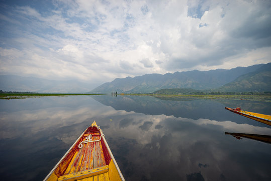 View over traditional boat or shikara - a type of wooden boat at Dal Lake, Khasmir. Shikara are of varied sizes and are used for multiple purposes, including transportation of people.