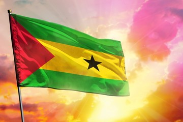 Fluttering Sao Tome and Principe flag on beautiful colorful sunset or sunrise background. Success concept.