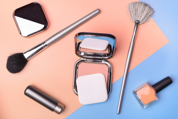 Flat view of cosmetics - lipstic, face-powder, brushes, nail polish