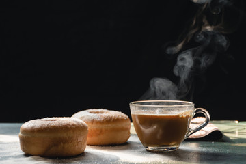 Donuts in the kitchen homemade food and a cup of coffee, Morning Nature light by window on wood table and black background,  Selective focus.