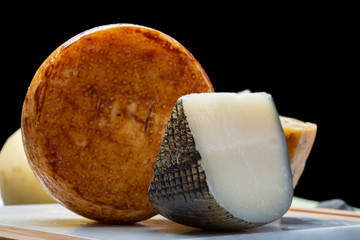 Variety of Italian pecorino cheeses, yellow aged, with black peppers from Nebrodi, white Il Palio and black molarotto, close up