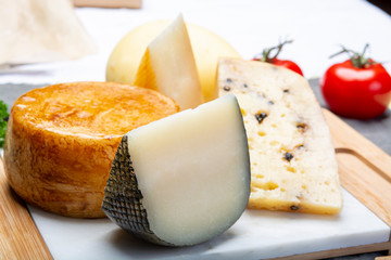 Variety of Italian pecorino cheeses, yellow aged, with black peppers from Nebrodi, white Il Palio and black molarotto, close up
