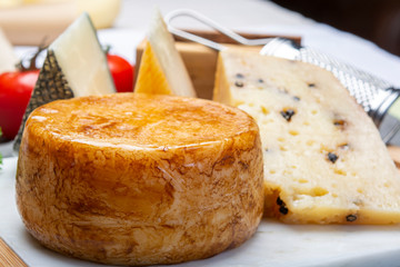 Variety of Italian pecorino cheeses, yellow aged, with black peppers from Nebrodi, white Il Palio and black molarotto, close up