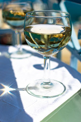 White wine served outside on balcony on glass table with sea view