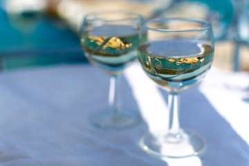 White wine served outside on balcony on glass table with sea view