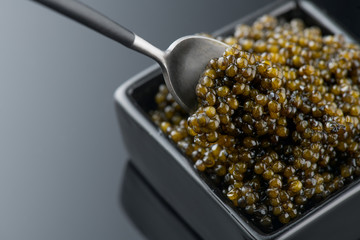 Black Caviar in spoon. High quality real natural sturgeon black caviar close-up. Delicatessen....