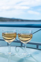 White wine served outside on balcony on glass table with sea view