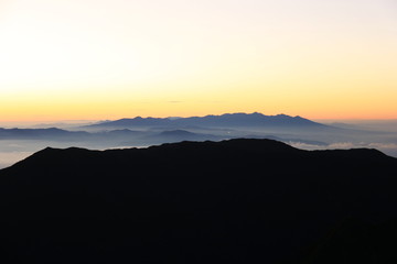 北アルプス　槍穂高連峰縦走　南岳山頂からの風景　蝶ヶ岳越しの朝焼けに映える八ヶ岳遠景
