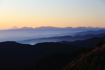 北アルプス　南岳山頂からの風景　朝焼けに映える富士山、南アルプス遠景