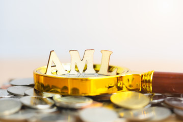 Wood block word AML (Anti Money Laundering) on blurred greenery background. Money laundering concept.