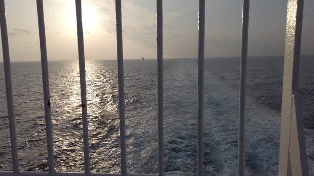 Watching the sunset over the ocean and reflections on the sea between the steel bars and hoping for a change - First-person 4K shoot
