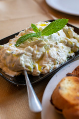 Tzatziki dip or sauce from Southeast Europe and Middle East made of salted strained yogurt mixed with cucumbers, garlic, salt, olive oil, vinegar or lemon juice, and dill, mint, parsley and thyme.
