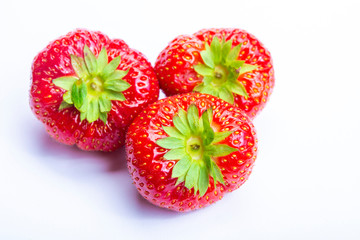 Three red ripe strawberries isolated on white background