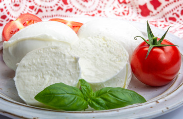 Italian soft cheese mozzarella, white cheese made from cow or buffalo milk with fresh green basil herb and red tomato