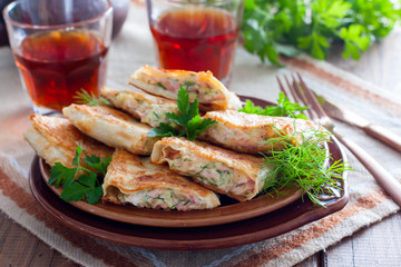 Squares of fried pita bread with sausage and cheese, horizontal