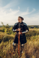 Female medieval knight poses in armor