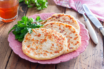 Cheese fried tortillas on a wooden table with fresh herbs, horizontal