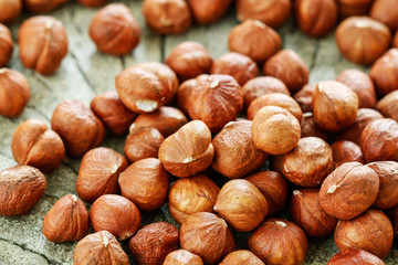 Hazelnuts on rough wooden background.