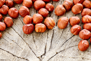 Hazelnuts on rough wooden background.