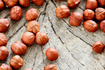 Hazelnuts on rough wooden background.