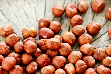 Hazelnuts on rough wooden background.