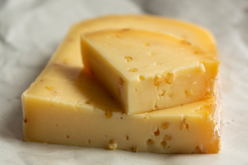 Piece of cow cheese with fenugreek seeds made in Belgian abbey by monks.