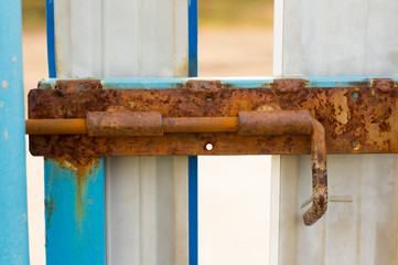 A rusty old bolt on the metal doors.