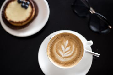 Breakfast with cappucino and cake with bluebarries in cafe