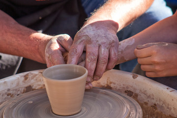 A potter craftsman transfers his skills to a student