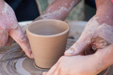 A potter craftsman transfers his skills to a student