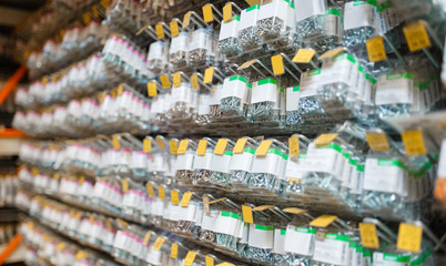 Rows of boxes with bolts in hardware store closeup