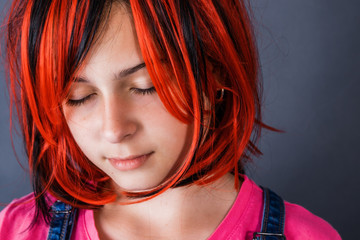 Teenage girl wanting to be like an adult dressed a bright red wig