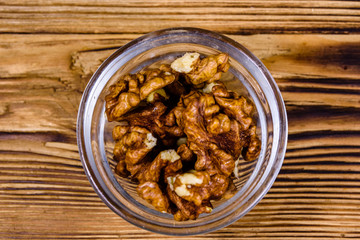 Cores of walnut in glass bowl on a wooden table. Top view