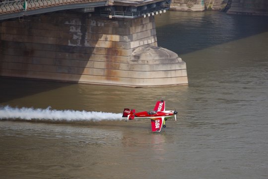 BUDAPEST, HUNGARY - MAY 1: Zoltan Veres fly under the Chainbridge as part of the May 1 celebration of 2014. Zoltan Veres is an European champion and Guiness record holder aerobatics pilot.