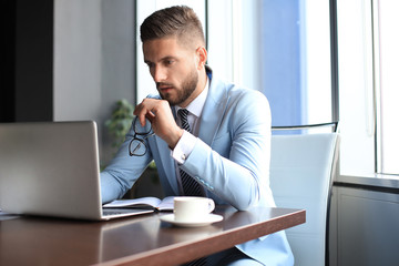 Naklejka premium Modern businessman thinking about something while sitting in the office