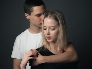 Young beautiful couple in love hugging in studio.