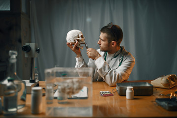 Psychiatrist in lab coat examines the human skull